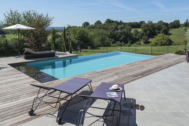 Piscine avec liner gris clair et margelles en pierres Prieuré