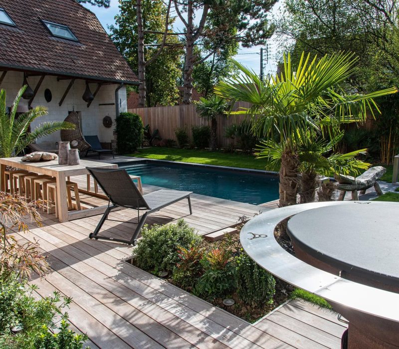 Piscine de luxe avec terrasse en bois dans un jardin calme