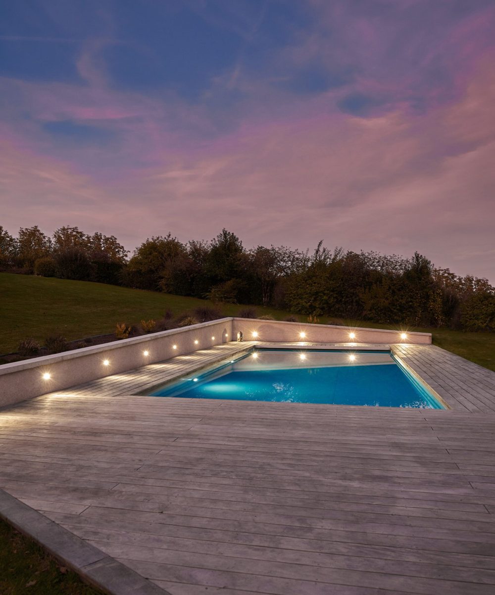 Piscine extérieure de 11 x 4.5 m avec spot leds et plage en bois exotique